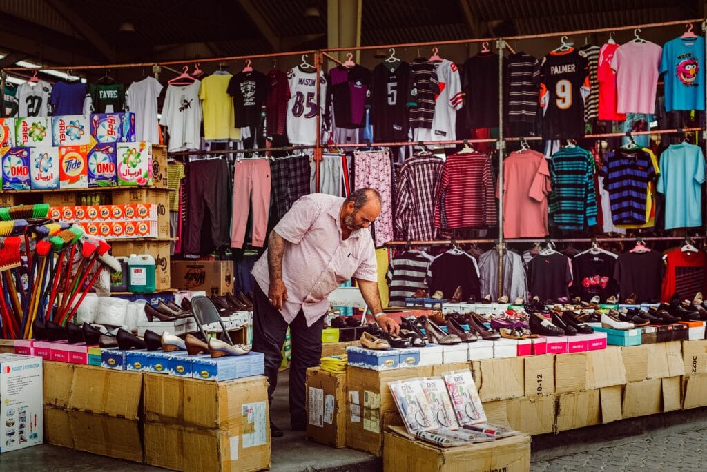 Kuwait Online Grocery Shopping: Overcoming Challenges for a Seamless Experience 3 A vendor arranges shoes at a vibrant street market in Kuwait City, highlighting local commerce.
